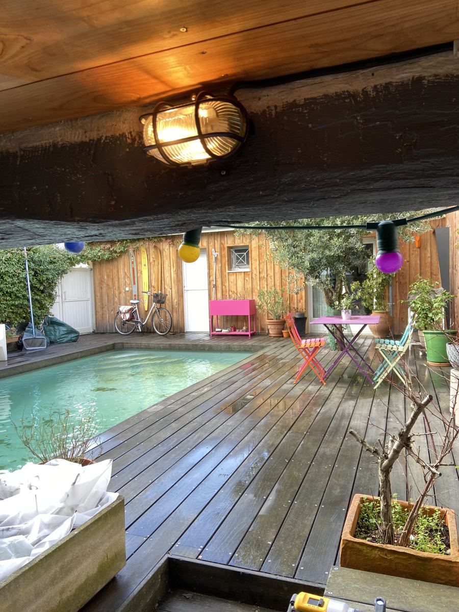 Applique extérieure installée sous un abri donnant sur le jardin et la piscine