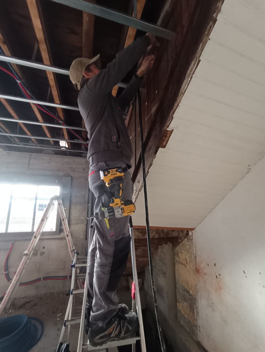 Antoine Lauth, électricien artisan, en intervention dans les combles pour le tirage de câbles