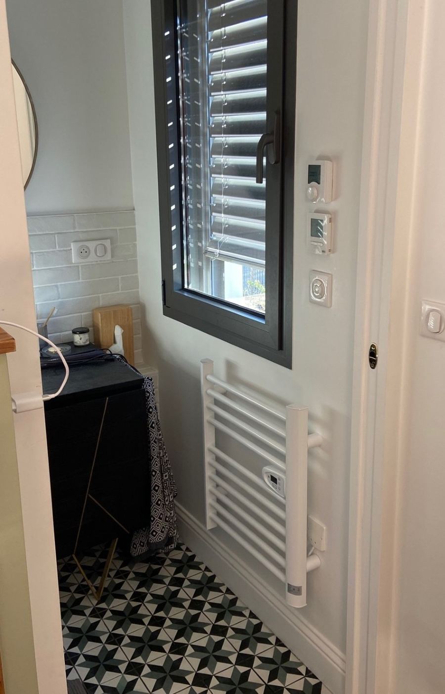 Installation d'un sèche-serviette électrique avec thermostats de régulation, salle de bain